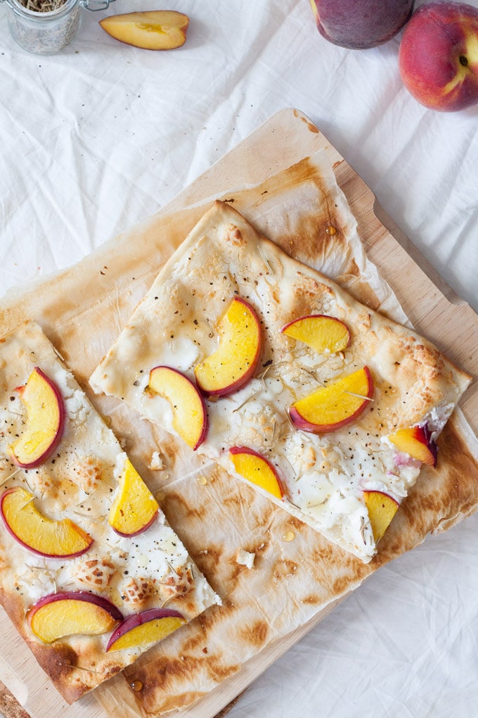 Schneller Flammkuchen mit Pfirsich, Ziegenkäse und Honig. Herzhaft, knusprig und in 20 Minuten auf dem Tisch - kochkarussell.com