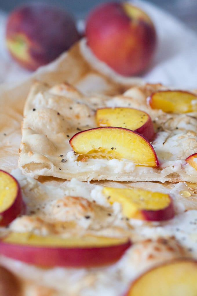 Schneller Flammkuchen mit Pfirsich, Ziegenkäse und Honig. Herzhaft, knusprig und in 20 Minuten auf dem Tisch - kochkarussell.com