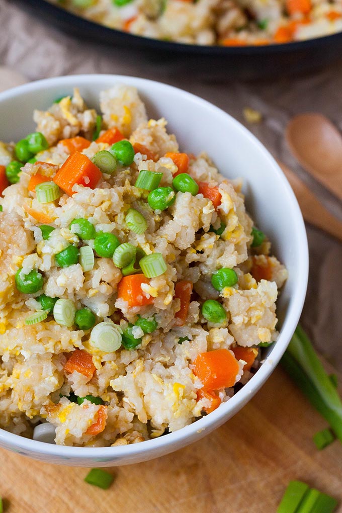 Bratreis in einer Schüssel mit Erbsen, Ei, Karotten und Frühlingszwiebeln