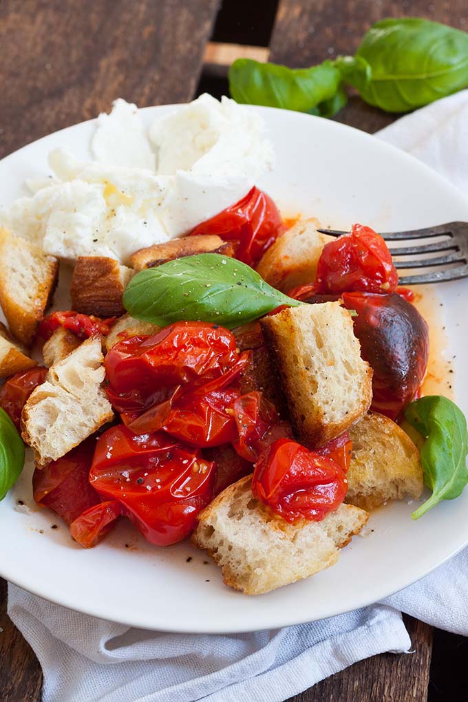 Der sommerliche Brotsalat mit gerösteten Tomaten und Mozzarella ist die perfekte Mischung aus knusprig, würzig und cremig. Schnell, einfach und unglaublich gut - kochkarussell.com