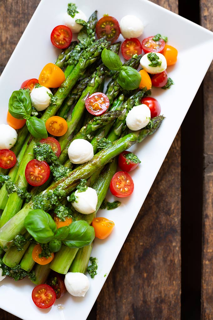 Spargel-Caprese-Salat mit Basilikum-Dressing ist SO GUT! Grüner Spargel, bunte Tomaten, Mozzarella und eine leichte Basilikum-Sauce, lecker! - Kochkarussell.com #salat #spargel #caprese #frühlingsrezept Spargel-Caprese-Salat mit Basilikum-Dressing - Kochkarussell Foodblog - leichtes Frühlingsrezept, perfekte Grillbeilage, lowcarb und ein schnelles Abendessen #salat #spargel #caprese #frühlingsrezept #lowcarb
