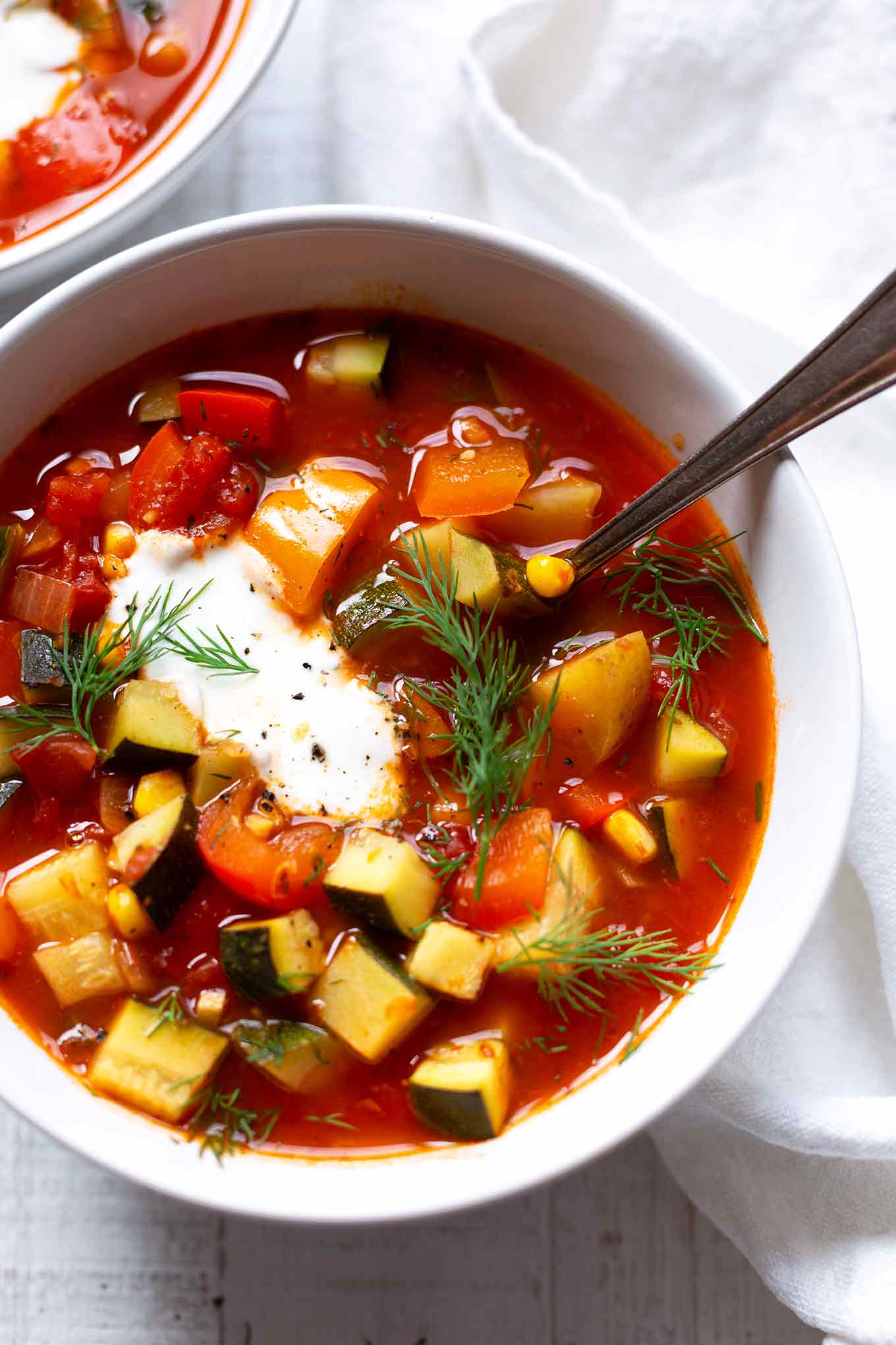 Diese vegetarische Gemüsesuppe ist schnell, einfach und vollgepackt mit viel gutem Sommergemüse. Ein leichtes Rezept, um ein paar Kalorien zu sparen und so lecker! - Kochkarussell.com #gemüsesuppe #rezept #sommerrezept #suppe #schnellundeinfach #soulfood