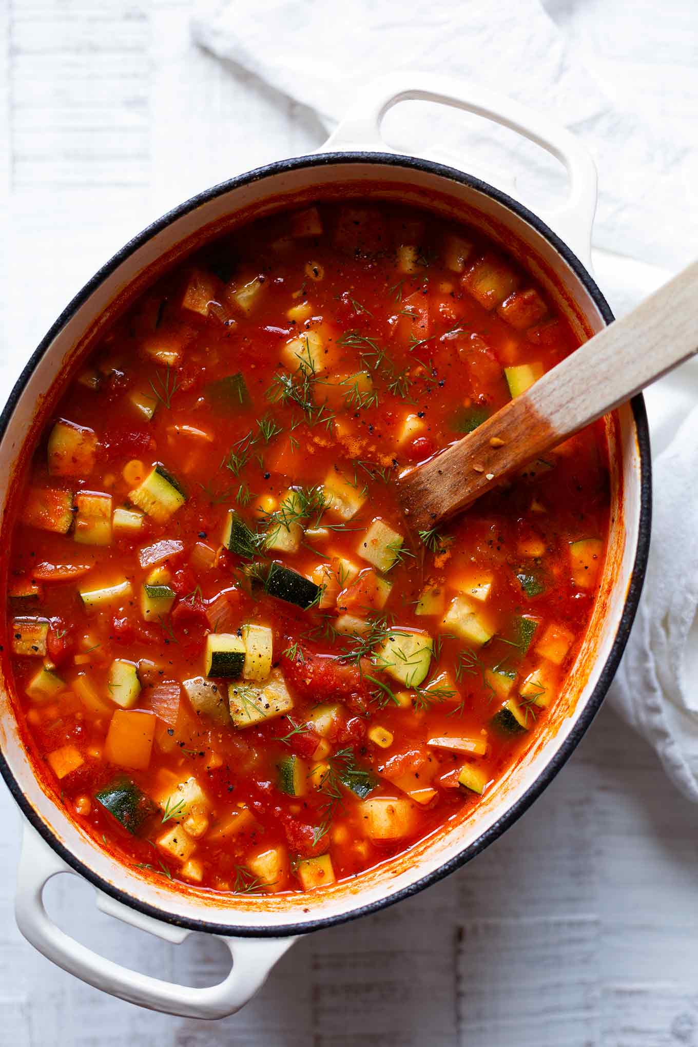 Diese vegetarische Gemüsesuppe ist schnell, einfach und vollgepackt mit viel gutem Sommergemüse. Ein leichtes Rezept, um ein paar Kalorien zu sparen und so lecker! - Kochkarussell.com #gemüsesuppe #rezept #sommerrezept #suppe #schnellundeinfach #soulfood