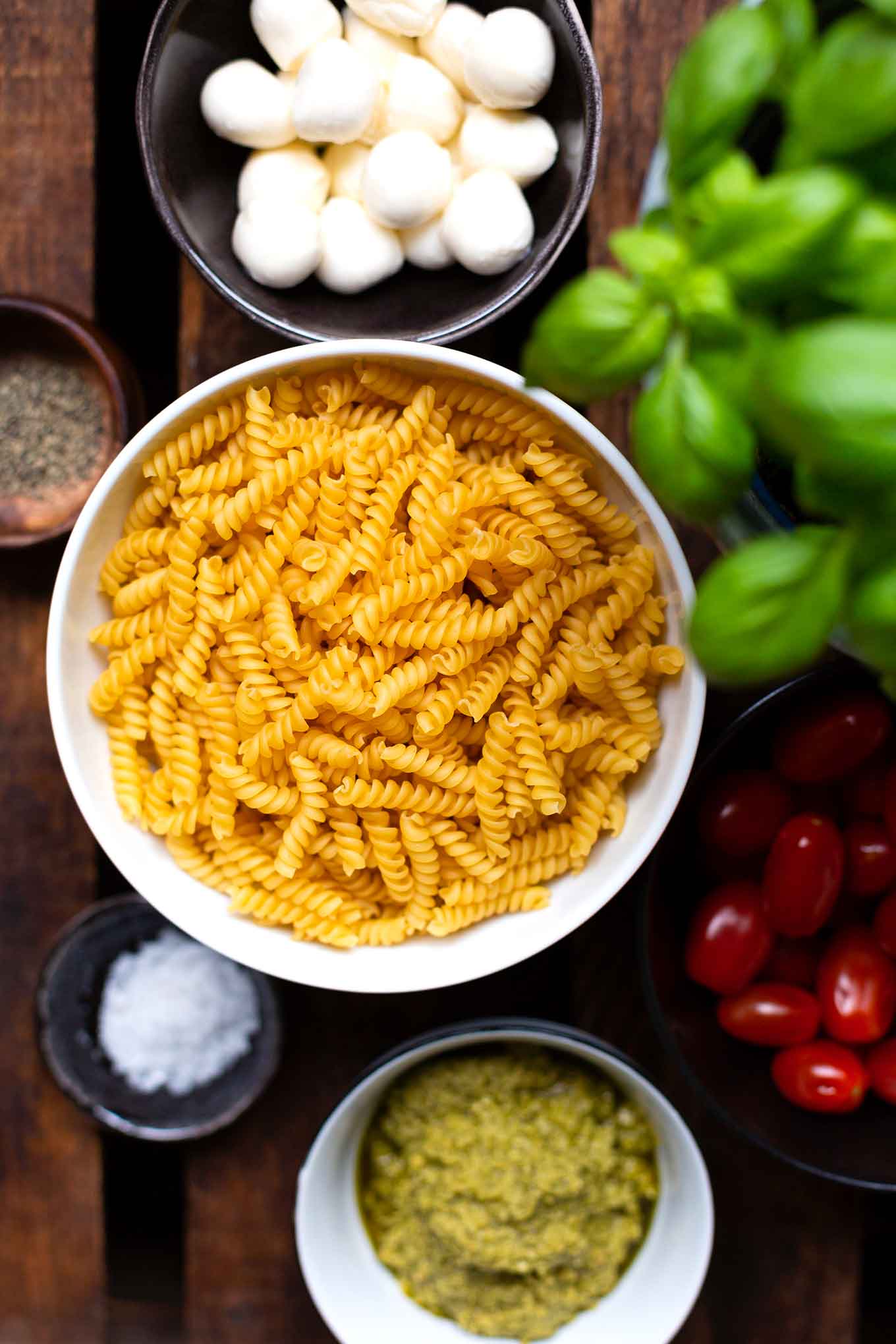 20-Minuten Caprese-Nudelsalat. Super einfach und SO lecker. Für dieses schnelle Rezept braucht ihr nur eine Handvoll Zutaten. Unbedingt probieren - Kochkarussell Foodblog #nudelsalat #pesto #caprese #kochkarussell