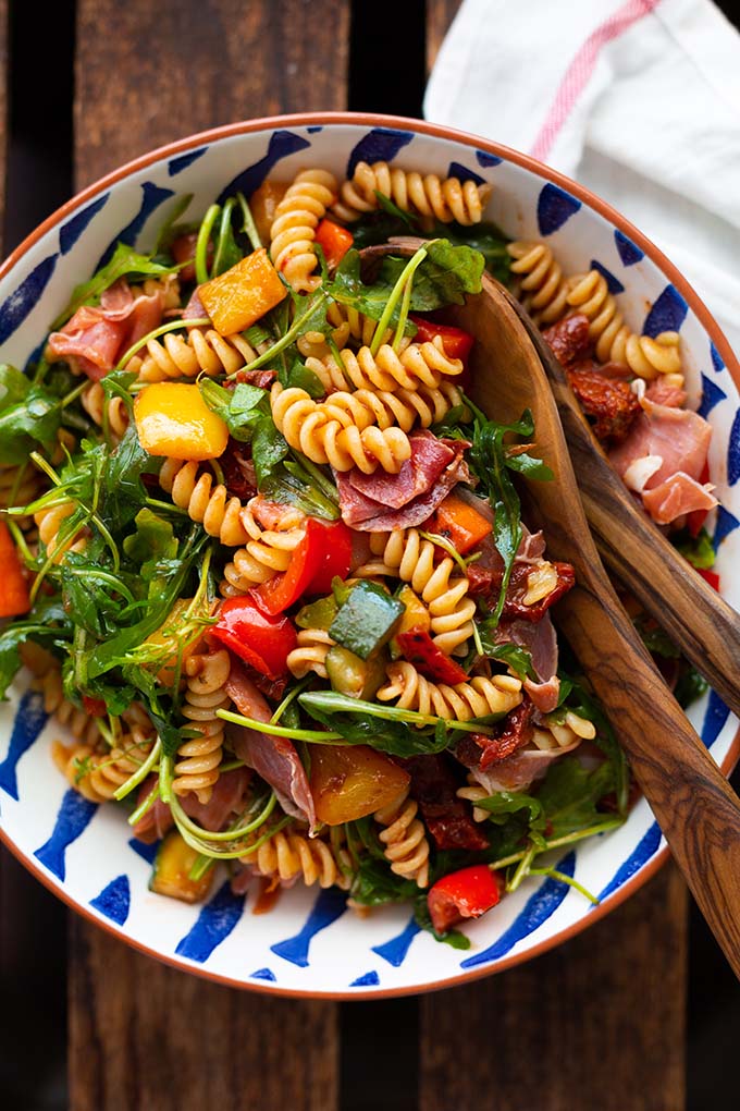 Mediterraner Nudelsalat mit Rucola & Serrano Schinken: In nur 20 Minuten fertig, perfekt zum Grillen & super lecker. Dieses Rezept inkl. Geheimzutat müsst ihr probieren! Kochkarussell - dein Foodblog für schnelle und einfache Feierabend Rezepte.