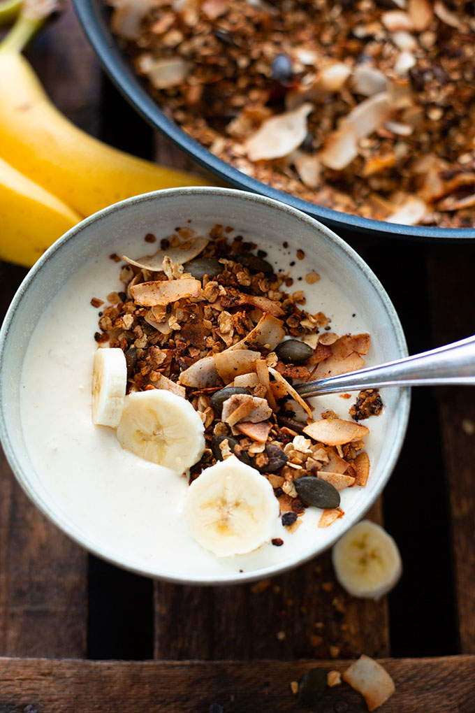 Selbstgemachte Granola in einer Schüssel mit Joghurt und Banane.
