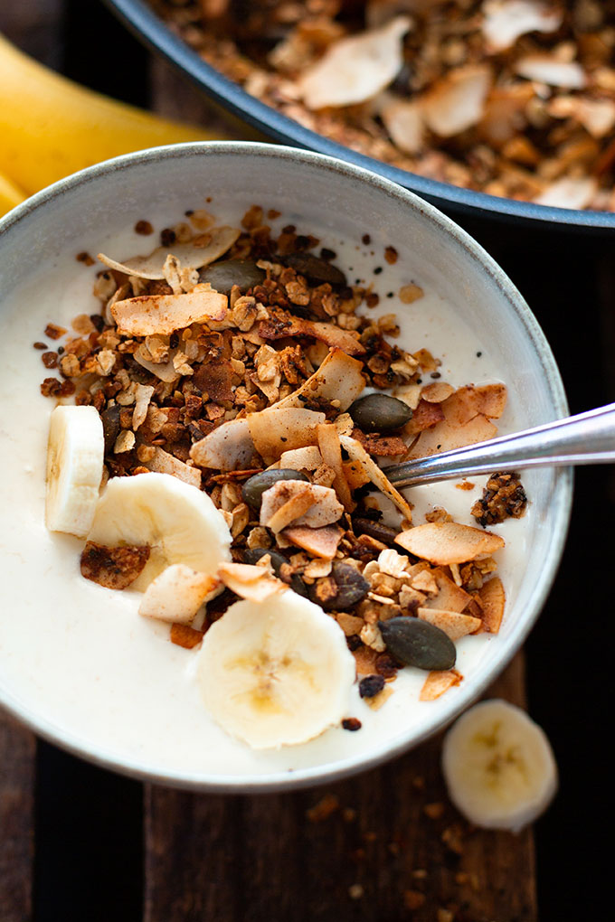 Selbstgemachte Granola in der Schüssel mit Joghurt und Banane.