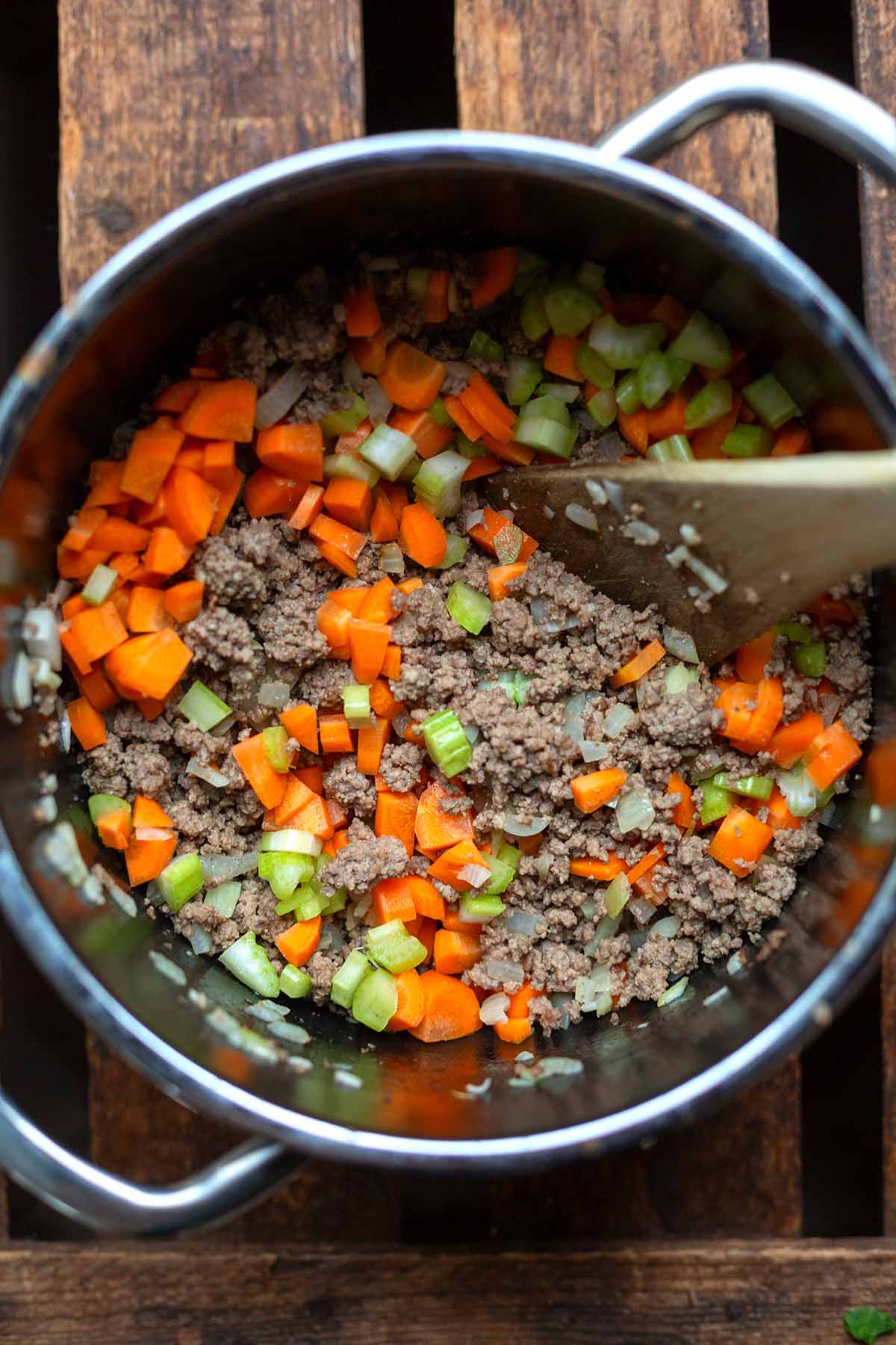 Angebratenes Hackfleisch & klein geschnittenes Gemüse in einem silbernen Kochtopf