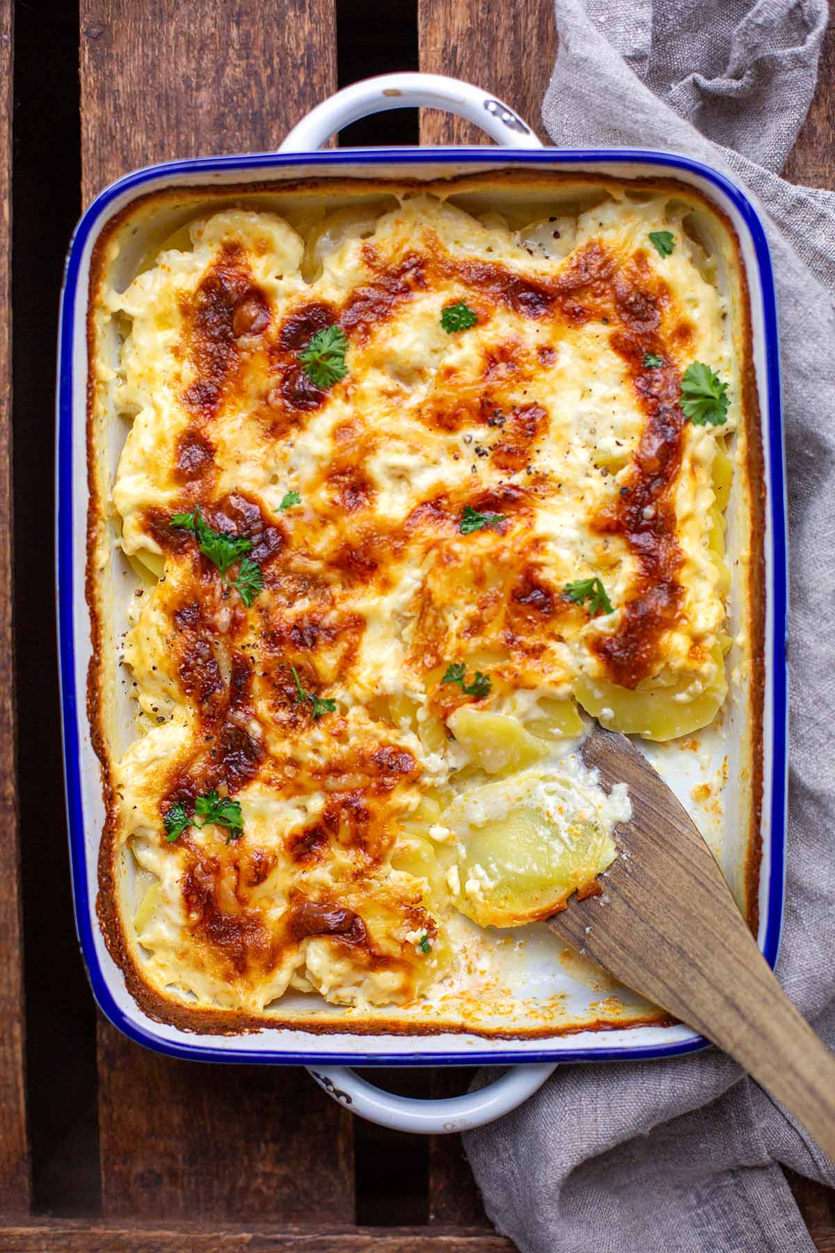 Auflaufform mit cremigem Kartoffelgratin und Petersilie