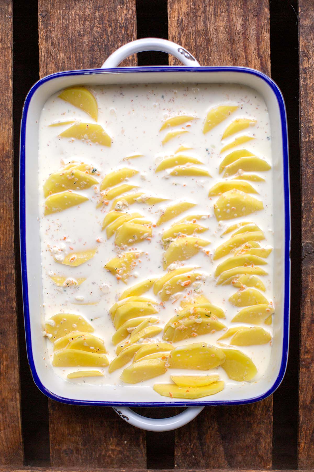 Kartoffeln geschichtet in die Auflaufform und überschüttet mit einer Sauce aus Milch und Sahne