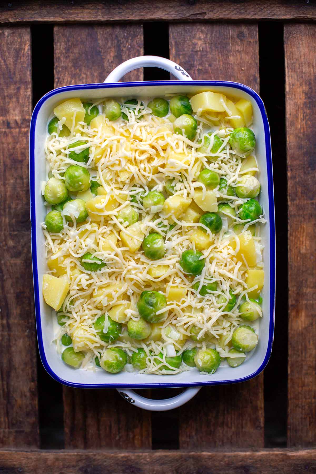 Rosenkohl-Auflauf mit Kartoffeln und Käse in Auflaufform vor dem Backen