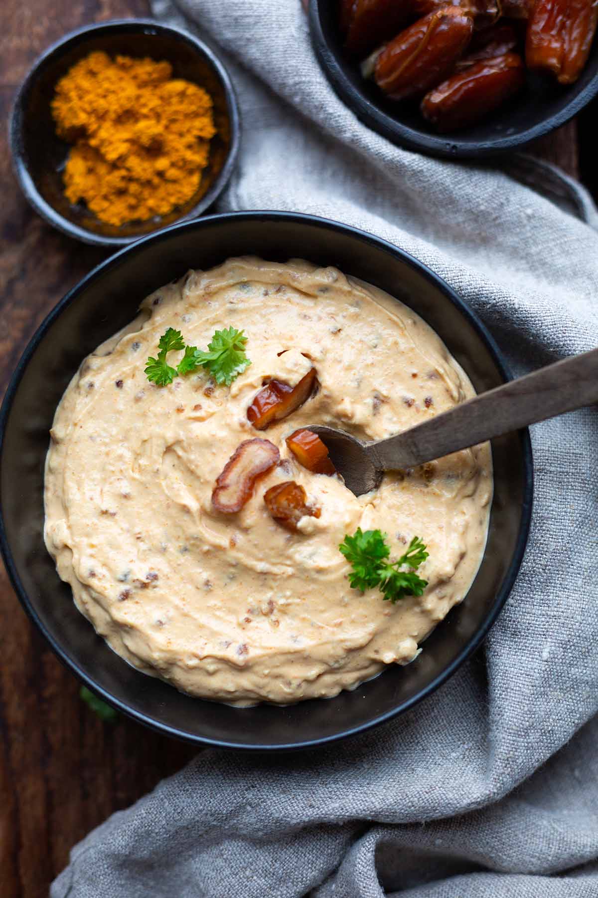 Curry-Dattel-Dip in einer Schüssel von oben, dekoriert mit Dattelstückchen