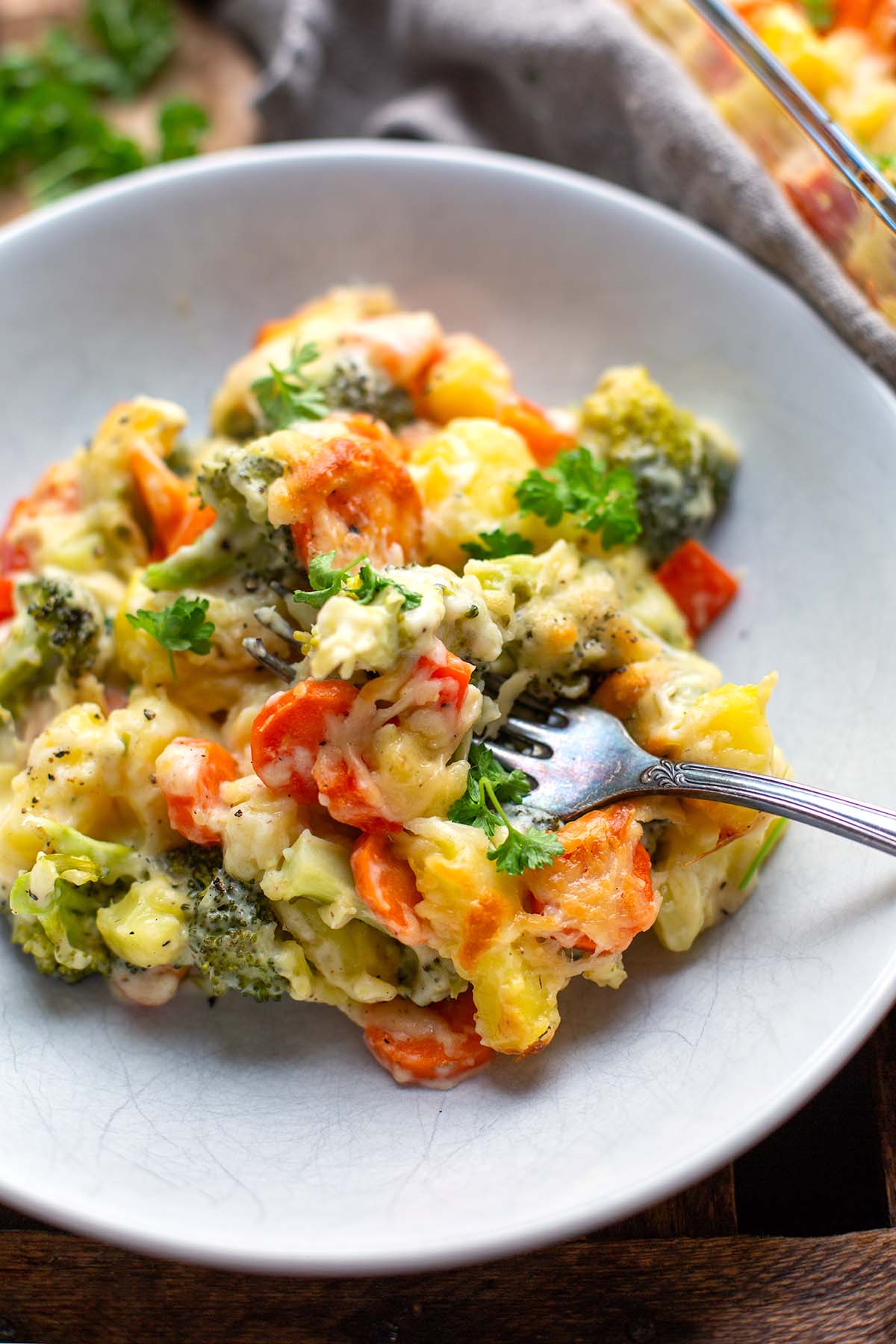 Gemüseauflauf mit Kartoffeln auf einem weißen Teller.