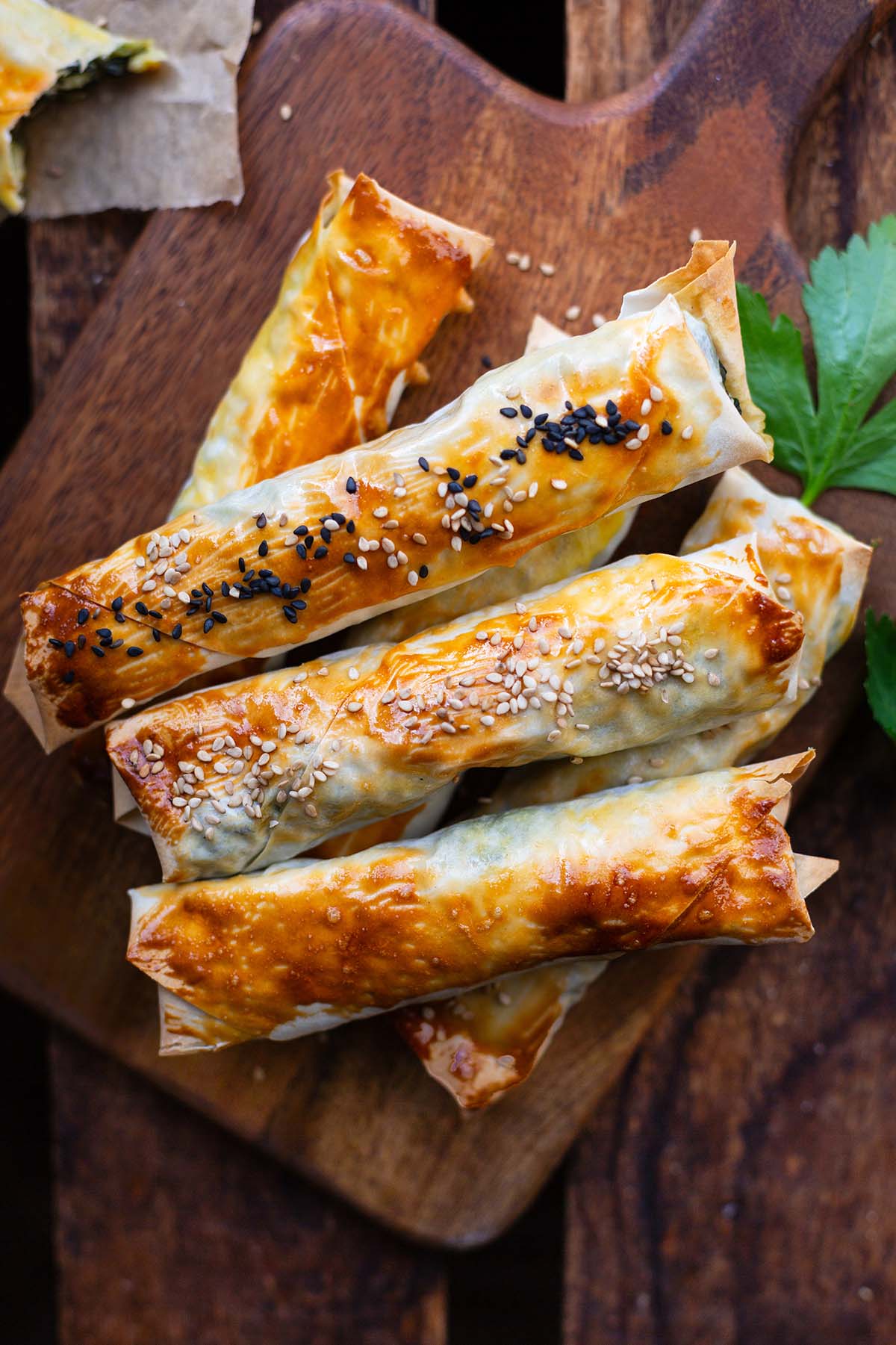 Börek mit Spinat und Feta, bestreut mit Sesam auf einem Holzbrett
