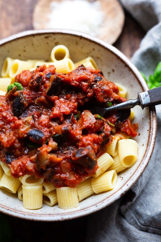 Fertige Pasta alla Norma in einer Schüssel und einer Gabel.