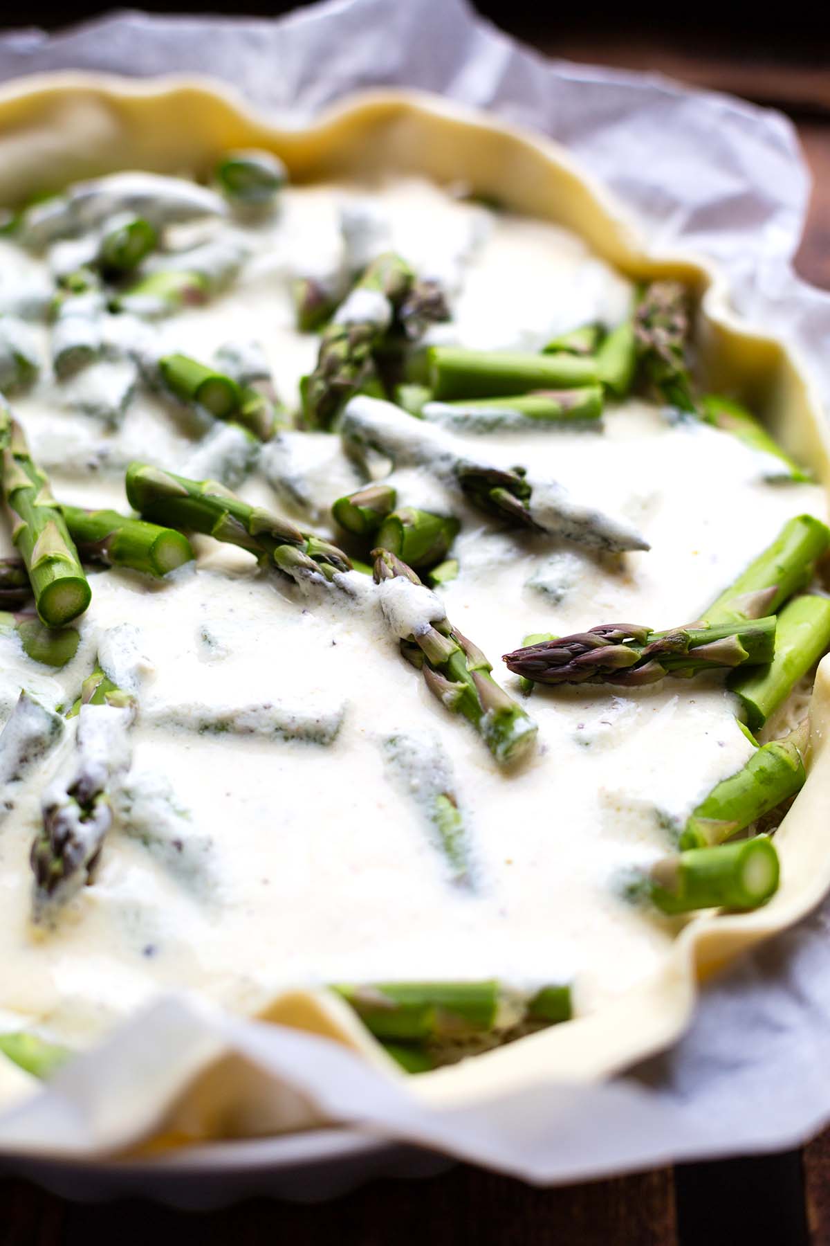Nahaufnahme von der Spargel-Quiche bevor sie in den Ofen geht.