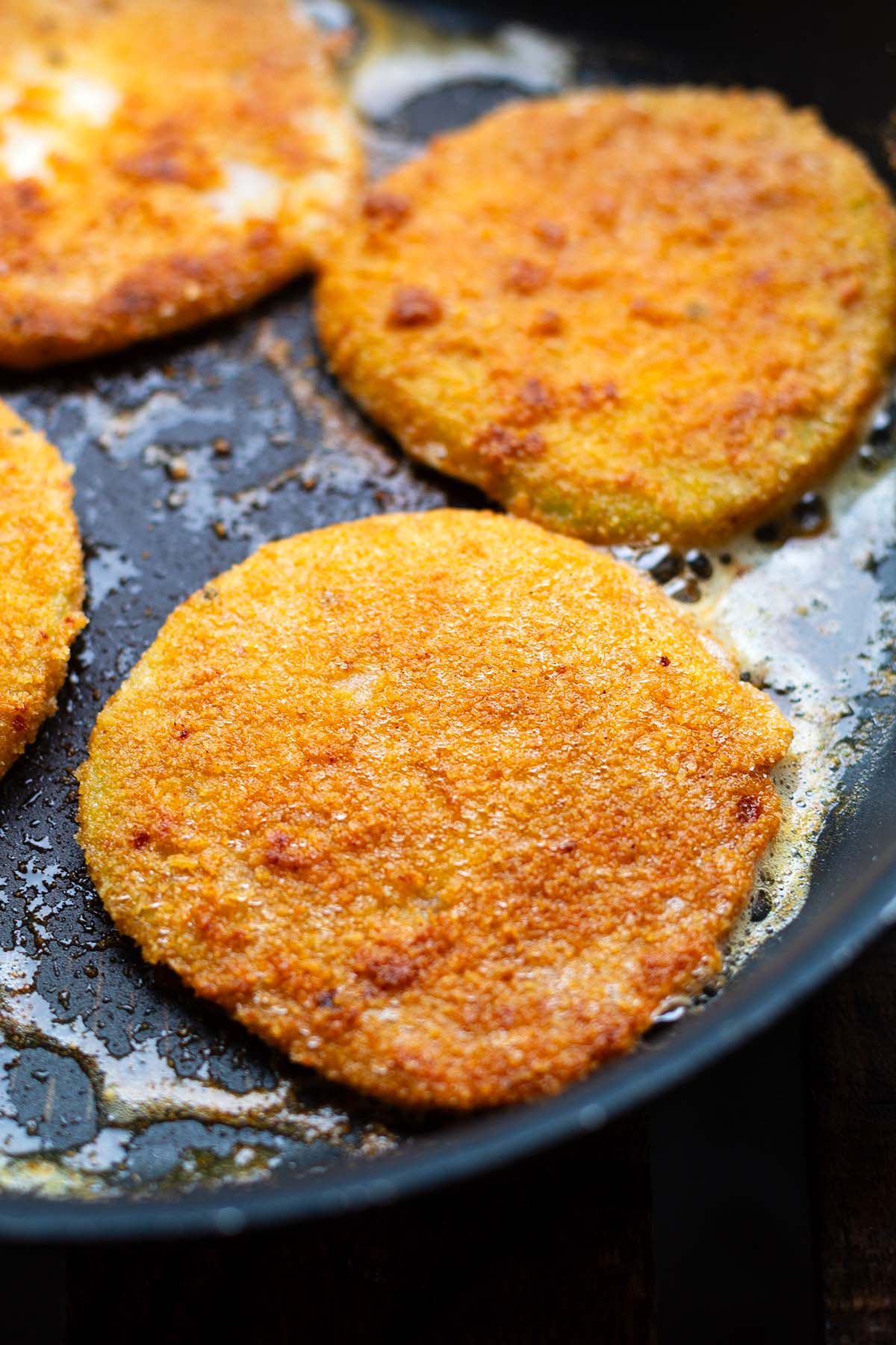 Knusprige Kohlrabischnitzel während des Bratens in einer Pfanne