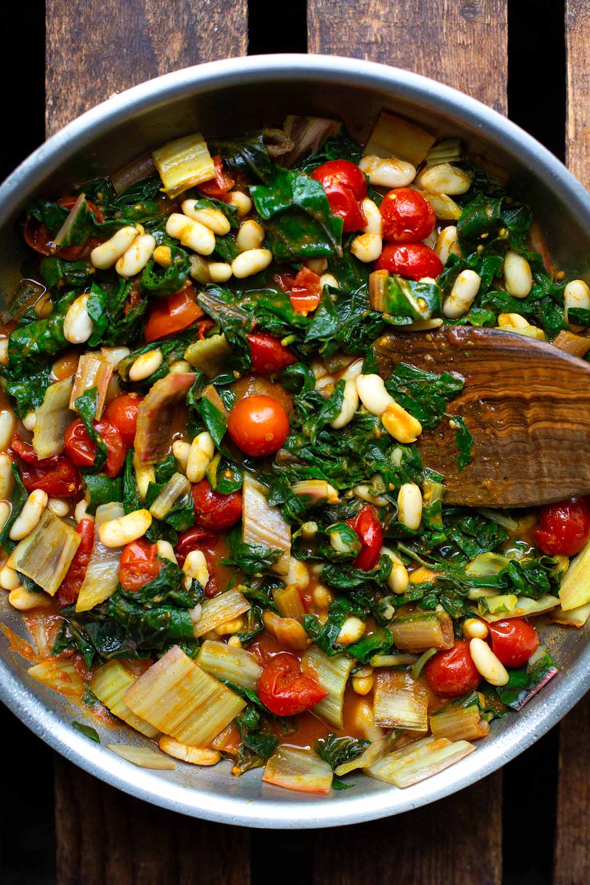 Fertige Mangold-Pfanne in einer silbernen Pfanne mit einem braunen Pfannenwender.