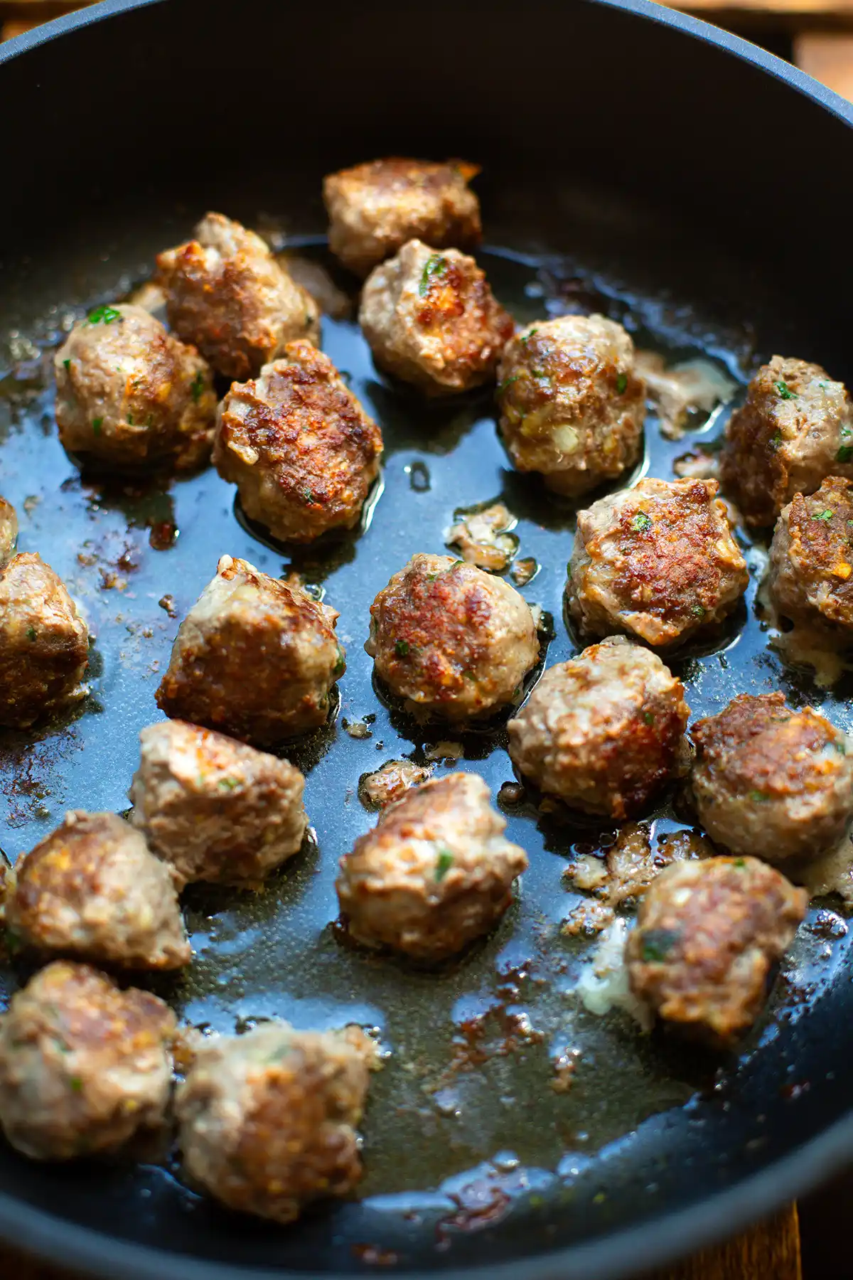 Angebratene Hackbällchen für die Albondigas in einer schwarzen Pfanne.