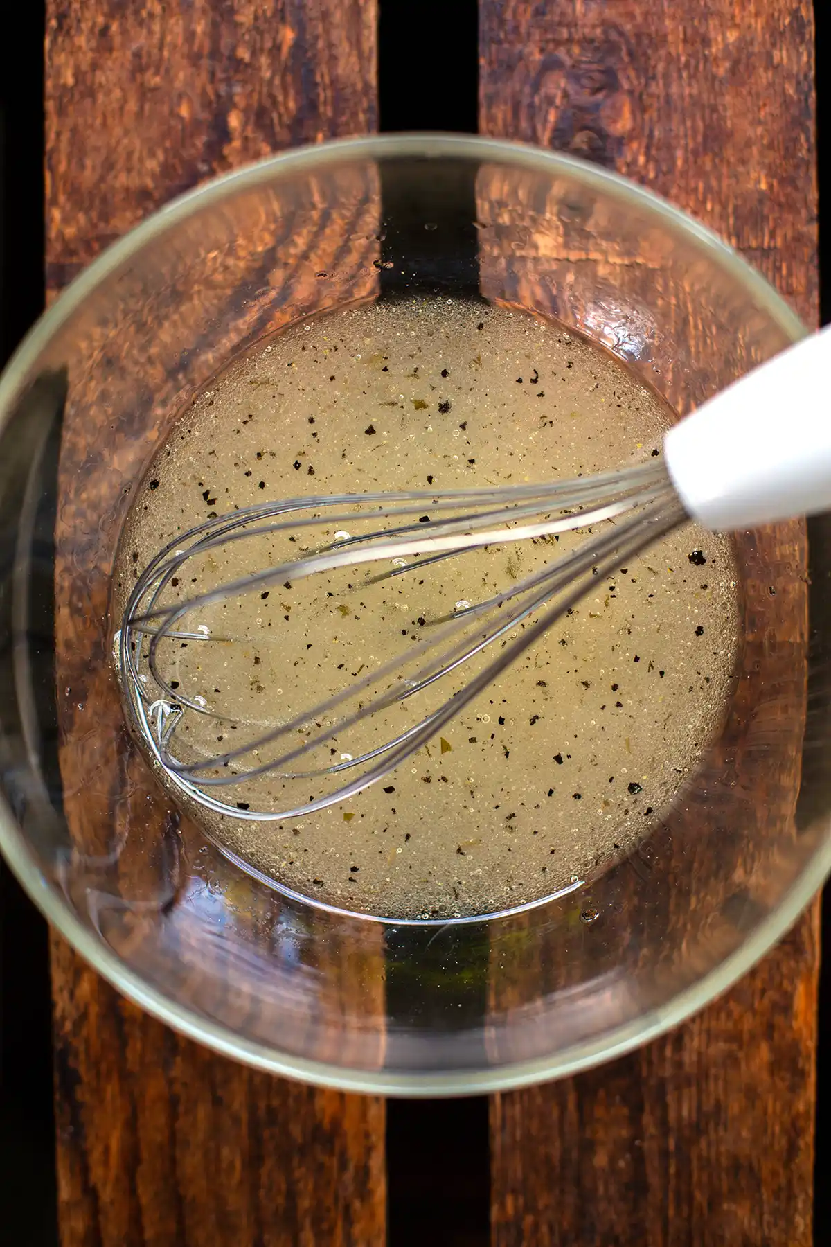 Zutaten für das Krautsalat-Dressing in einer großen Glasschüssel - verrührt mit einem Schneebesen.